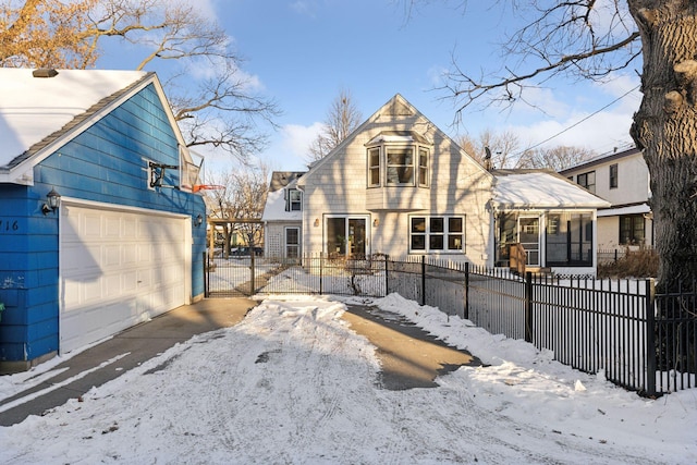 view of front of home with a garage, fence private yard, and a gate