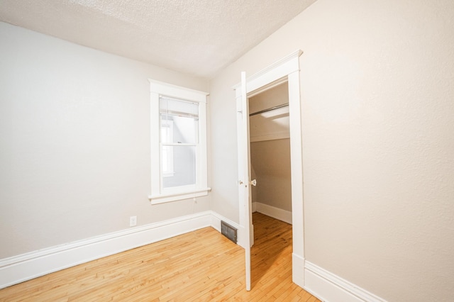 unfurnished bedroom with hardwood / wood-style flooring and a textured ceiling