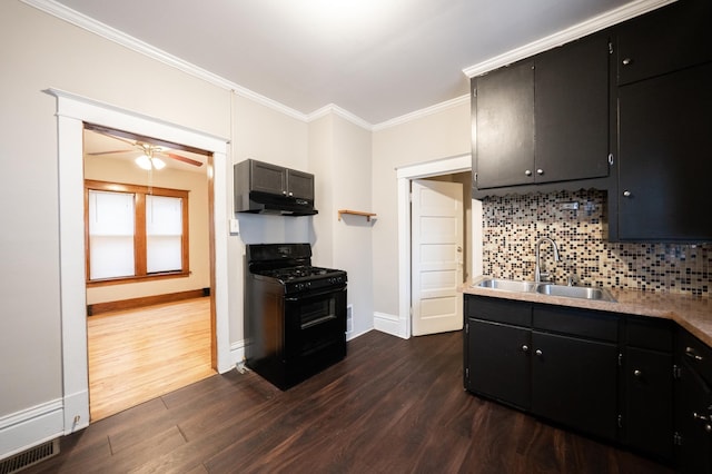 kitchen featuring sink, black range with gas stovetop, dark hardwood / wood-style flooring, backsplash, and ornamental molding