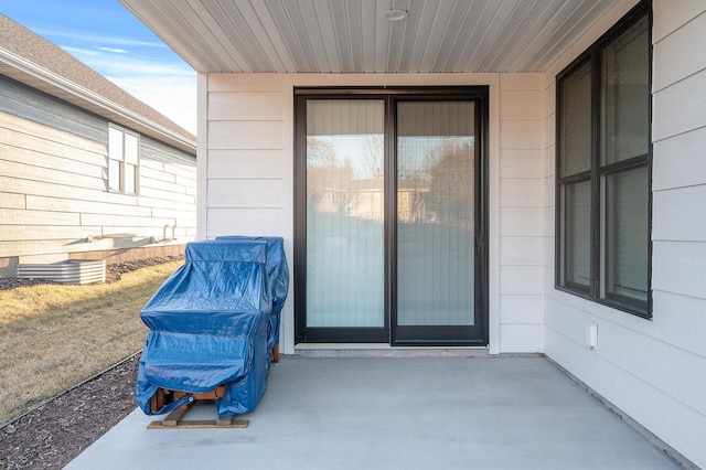 view of exterior entry with a patio