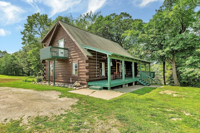 rear view of property featuring a patio and a lawn