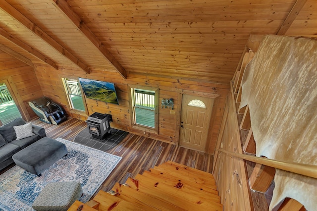 living room featuring wood ceiling, wooden walls, and a wood stove