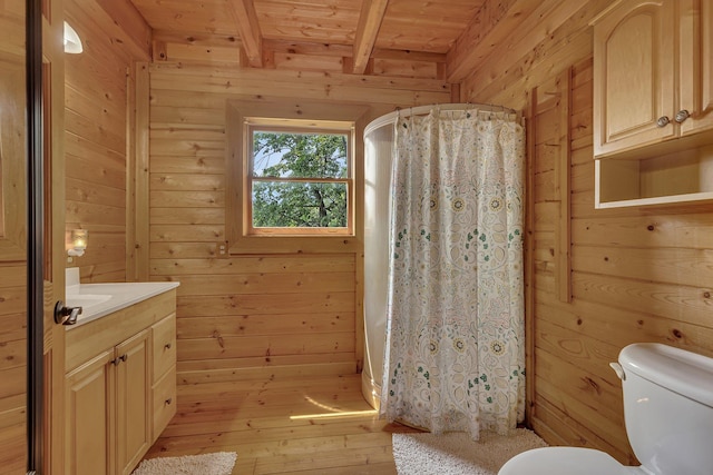 bathroom with beam ceiling, vanity, wood ceiling, and wood walls