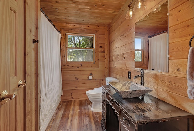 bathroom featuring hardwood / wood-style flooring, vanity, wooden walls, and wooden ceiling