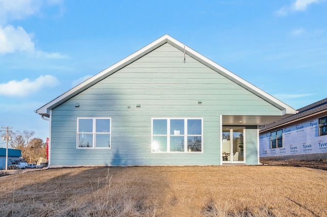 rear view of property with a lawn