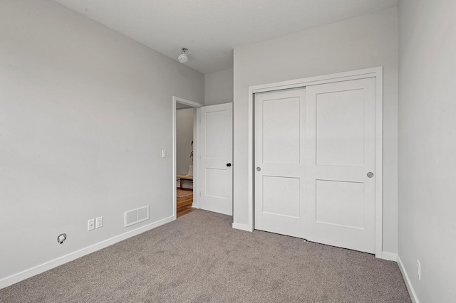 unfurnished bedroom with carpet flooring and a closet