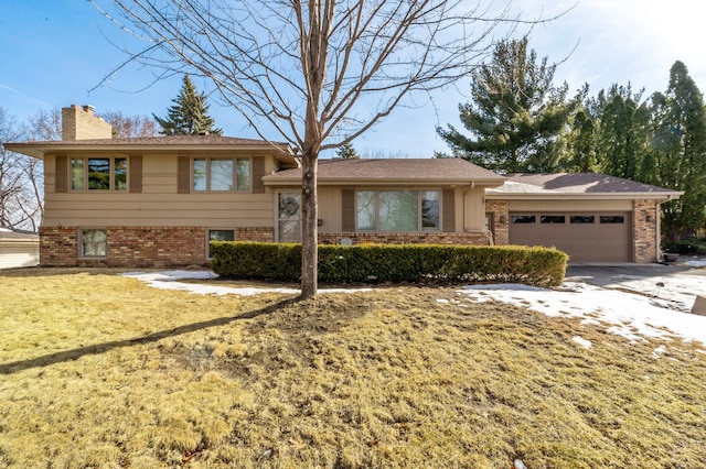 tri-level home with brick siding, driveway, a chimney, and a garage