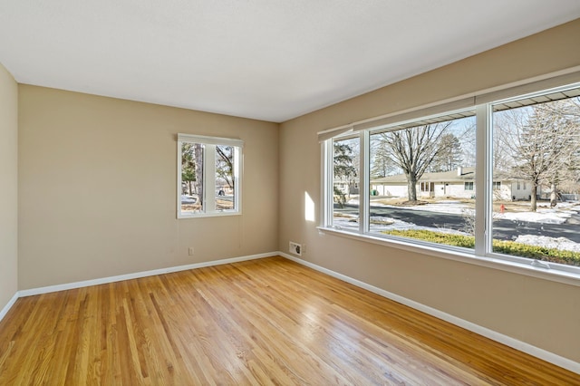 unfurnished room featuring baseboards and light wood-style floors