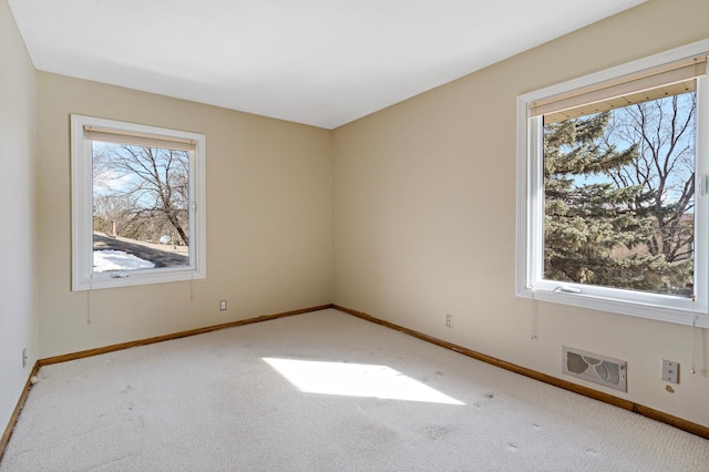 carpeted spare room featuring baseboards and visible vents