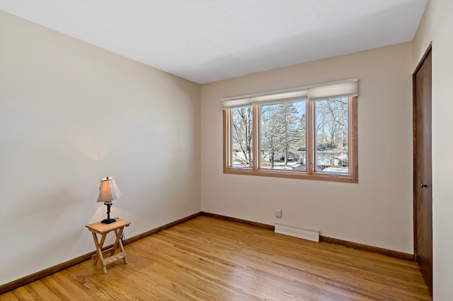 unfurnished room featuring light wood-style flooring, visible vents, and baseboards