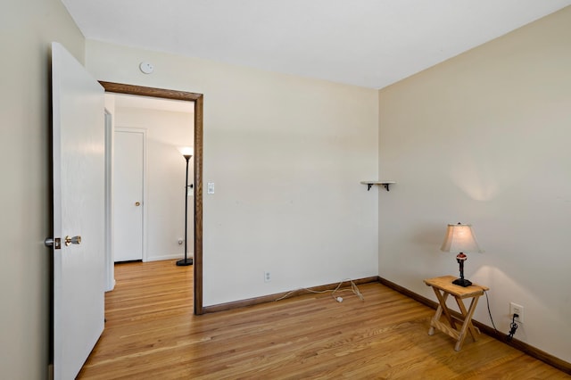 spare room with light wood-style flooring and baseboards