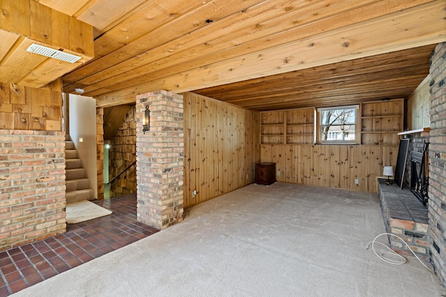 unfurnished living room with visible vents, carpet floors, a fireplace, and stairs