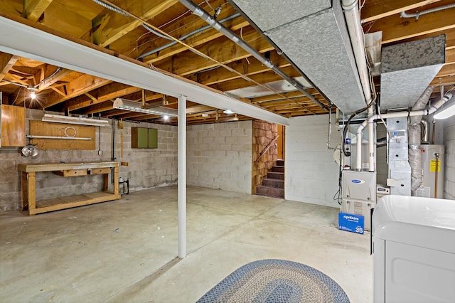 unfinished below grade area with gas water heater, stairway, and washer / clothes dryer