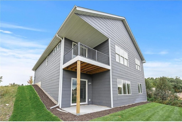 back of property featuring a lawn and a patio