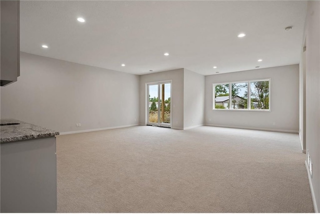 unfurnished living room with light colored carpet