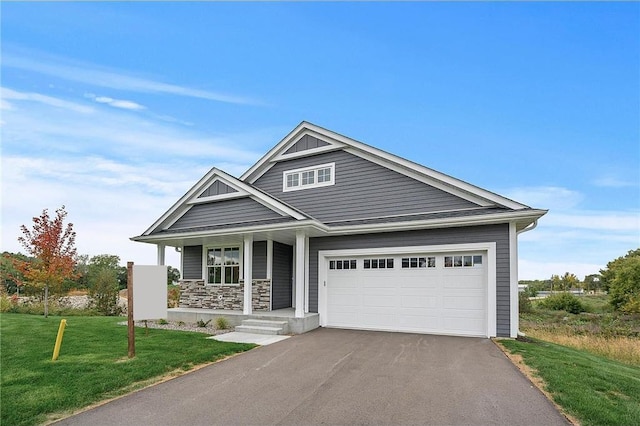 craftsman-style house with a garage, covered porch, and a front lawn