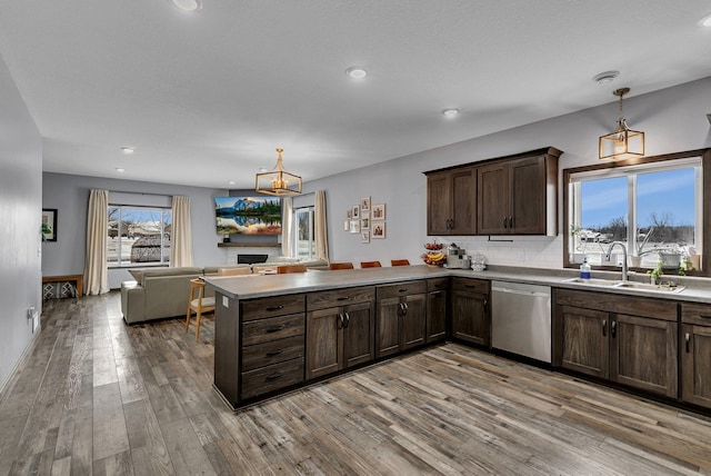 kitchen with decorative light fixtures, dishwasher, sink, and dark brown cabinets