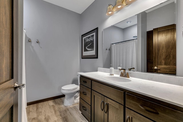 bathroom with walk in shower, vanity, toilet, and hardwood / wood-style floors