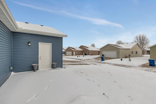 snowy yard featuring a garage