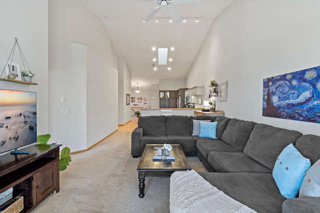 carpeted living room with track lighting and high vaulted ceiling