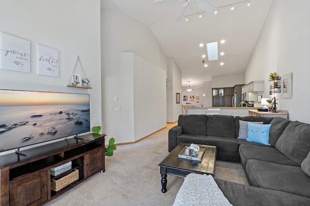 living room featuring high vaulted ceiling, track lighting, light colored carpet, and ceiling fan