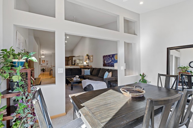 dining area with light carpet and a high ceiling