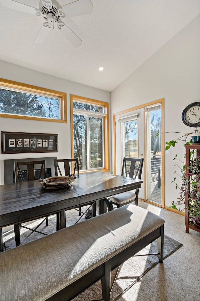 carpeted dining room featuring ceiling fan and lofted ceiling