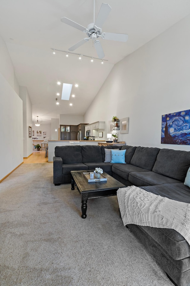 living room featuring high vaulted ceiling, light colored carpet, and ceiling fan