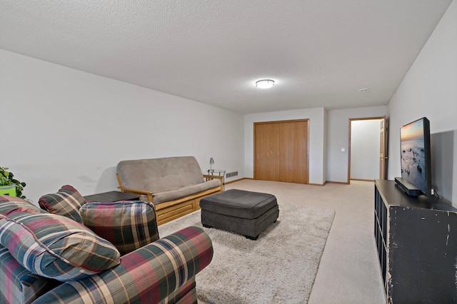 carpeted living room featuring a textured ceiling