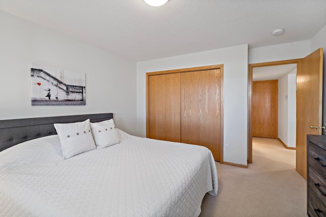 carpeted bedroom with a textured ceiling and a closet