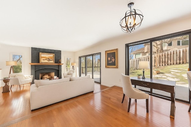 7720 Shaughnessy Rd, Edina, MN 55439 - living area featuring wood-type flooring, plenty of natural light, a chandelier, and a fireplace