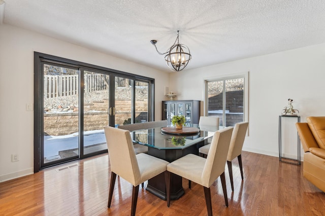 7720 Shaughnessy Rd, Edina, MN 55439 - dining area with a chandelier, wood finished floors, and a textured ceiling