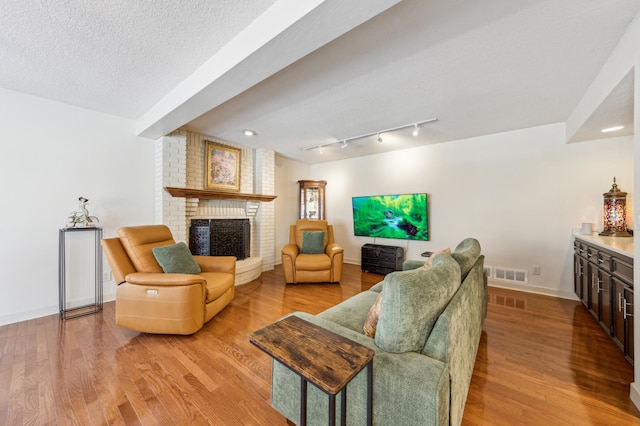 7720 Shaughnessy Rd, Edina, MN 55439 - living room featuring a brick fireplace, wood finished floors, a textured ceiling, and a dry bar