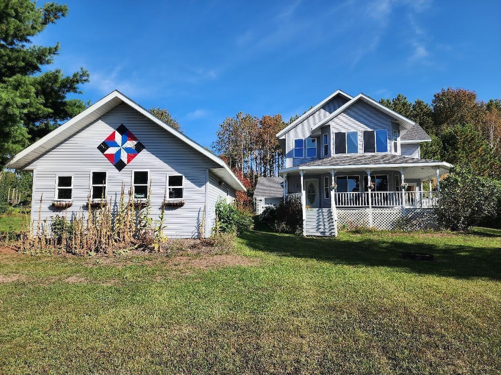 back of property with a yard and covered porch