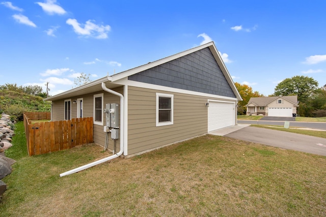 view of side of home featuring a garage and a lawn