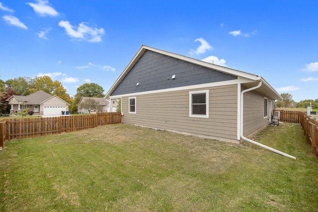 rear view of house with a garage and a lawn