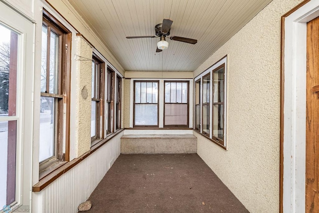 unfurnished sunroom featuring ceiling fan