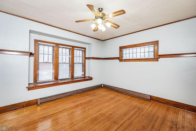 empty room featuring hardwood / wood-style flooring, ceiling fan, ornamental molding, and a textured ceiling