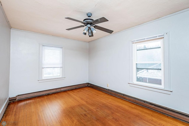 empty room with crown molding, hardwood / wood-style flooring, ceiling fan, and baseboard heating