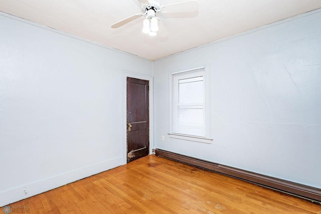 empty room featuring ceiling fan, a baseboard radiator, and hardwood / wood-style floors