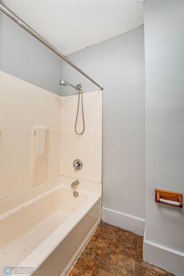 bathroom featuring shower / bathing tub combination and a textured ceiling