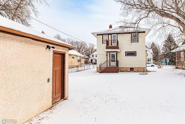 view of snow covered back of property