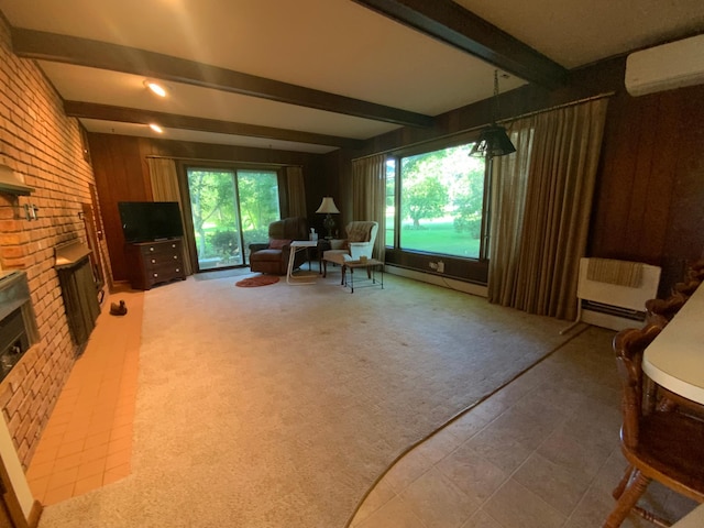 sitting room featuring beam ceiling, carpet floors, an AC wall unit, and plenty of natural light