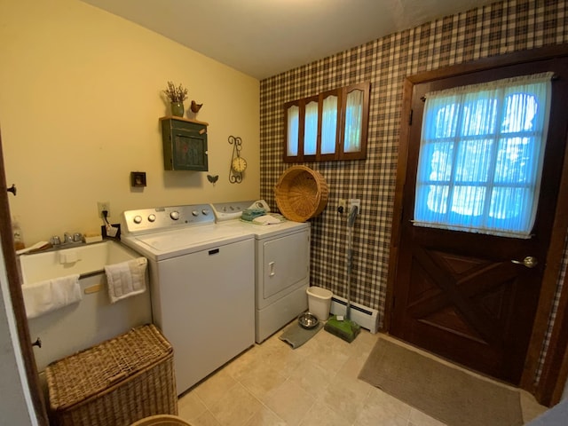 clothes washing area with washing machine and dryer and a baseboard radiator