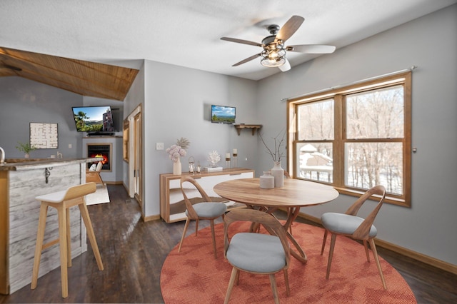 dining area with vaulted ceiling, dark wood-type flooring, and ceiling fan