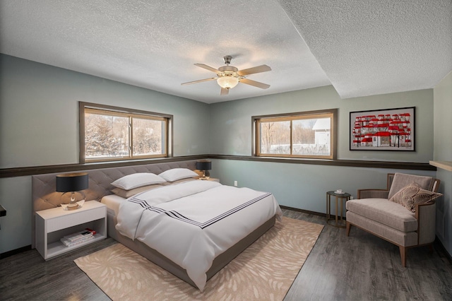 bedroom featuring ceiling fan, dark hardwood / wood-style flooring, and a textured ceiling