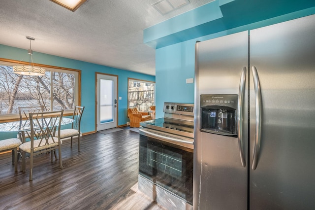 kitchen with dark hardwood / wood-style flooring, pendant lighting, a textured ceiling, and appliances with stainless steel finishes