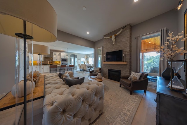 living room featuring a stone fireplace and light hardwood / wood-style floors