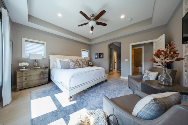 bedroom with ceiling fan and a tray ceiling