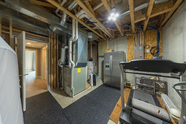 basement featuring water heater, stainless steel refrigerator with ice dispenser, heating unit, and electric panel